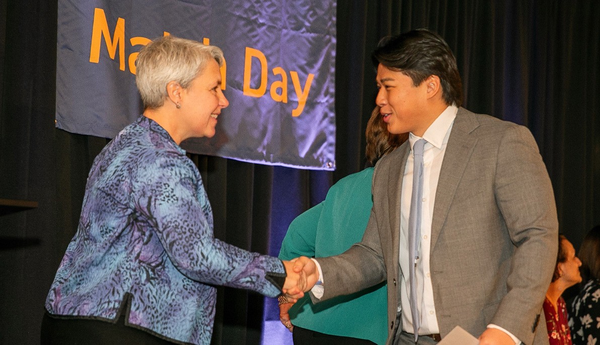 NYITCOM Dean Nicole Wadsworth shakes hands with NYITCOM student Sean Tan