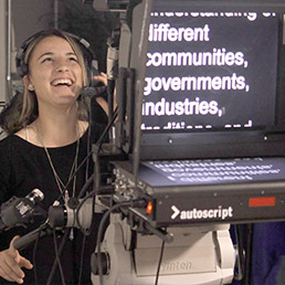 An NYIT student operates a studio camera equipped with a teleprompter for Globesville.