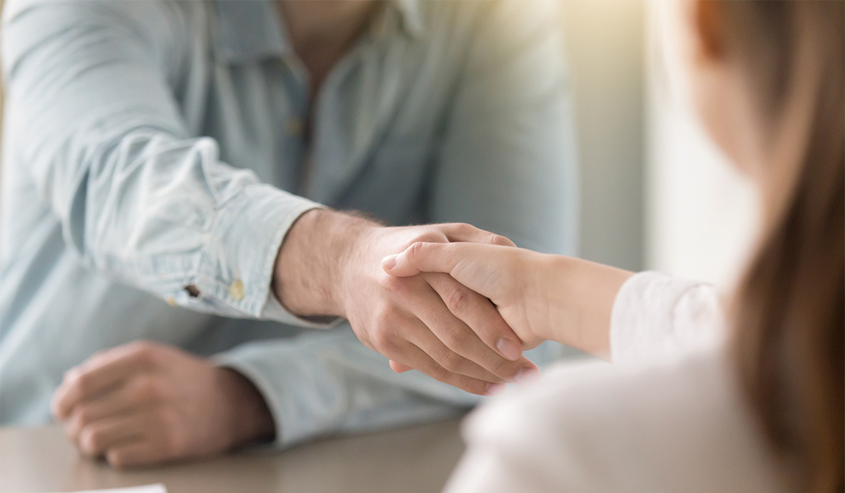 a job candidate shaking hands with an interviewer