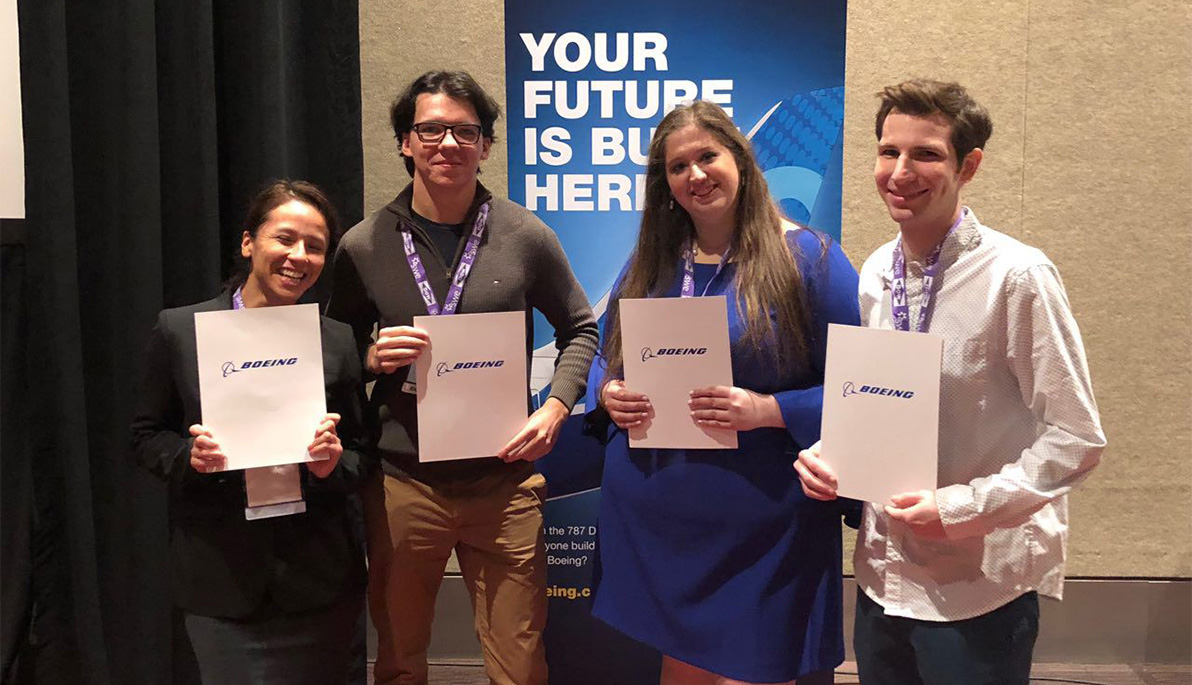 NYIT students holding offer packets from Boeing at the SWE Conference.
