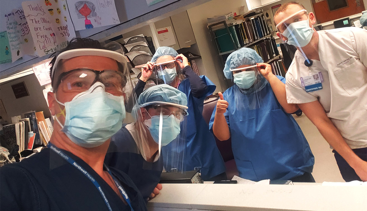 Front-line healthcare workers in scrubs and New York Tech-manufactured 3-D PPE gear.