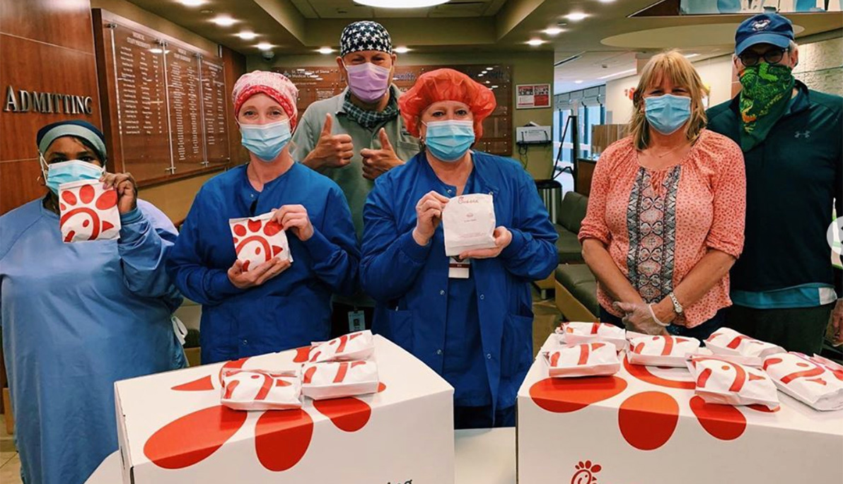 Masked hospital staff posing with food delivered by New York Tech