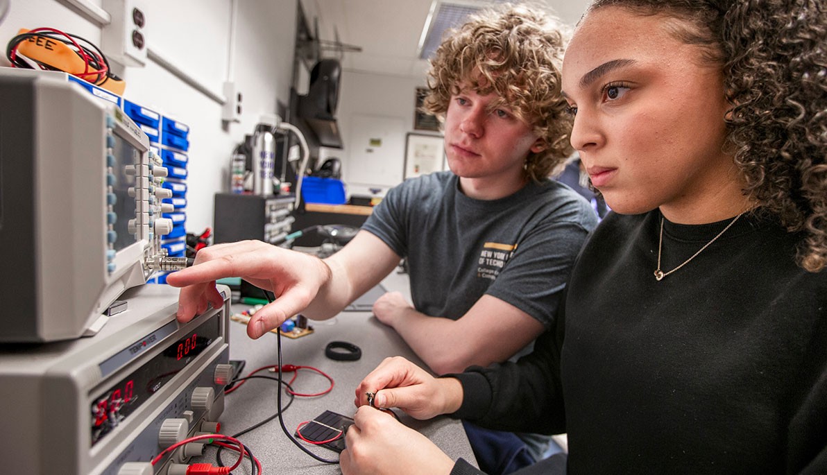 Two students looking at engineering equipment
