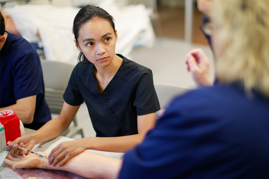 A medical student practices with a needle.