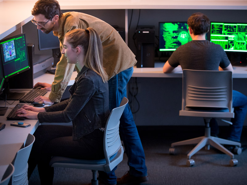 Students and an instructor working in a cybersecurity lab. 