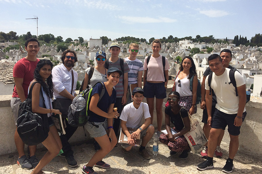 A group of New York Tech Architecture students stands outdoors to pose for a photo during a Summer Abroad trip.