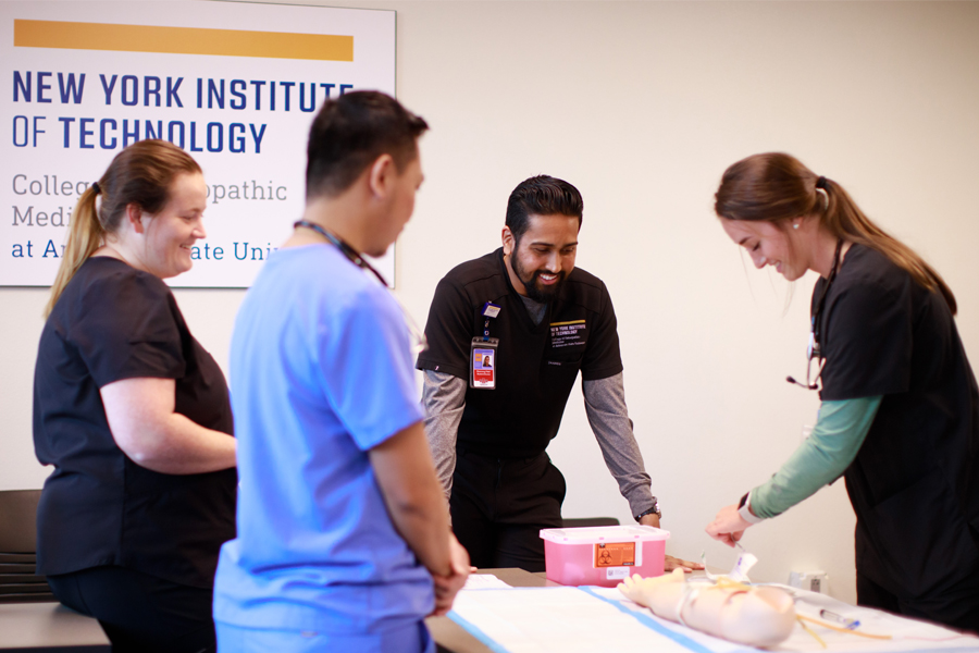 Four NYITCOM-Arkansas students learn how to draw blood from a venous training arm.