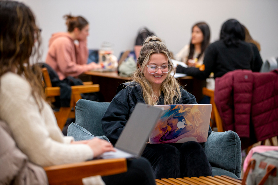 multiple groups of students studying in a student lounge.