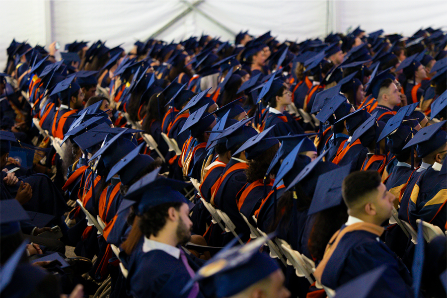 Students seated at commencement with their caps and gowns. 