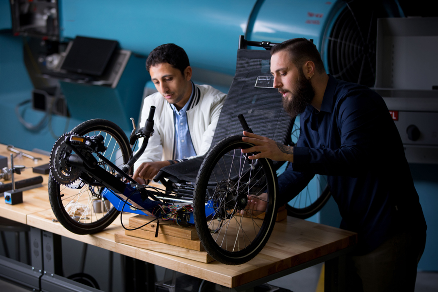 Two New York Tech graduate students design an experiment with bicycle wheels and gears.