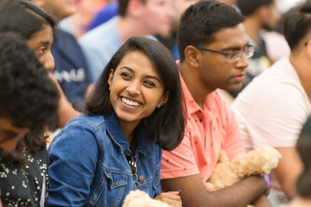 A student smiles and leans forward while sitting in class at New York Tech.