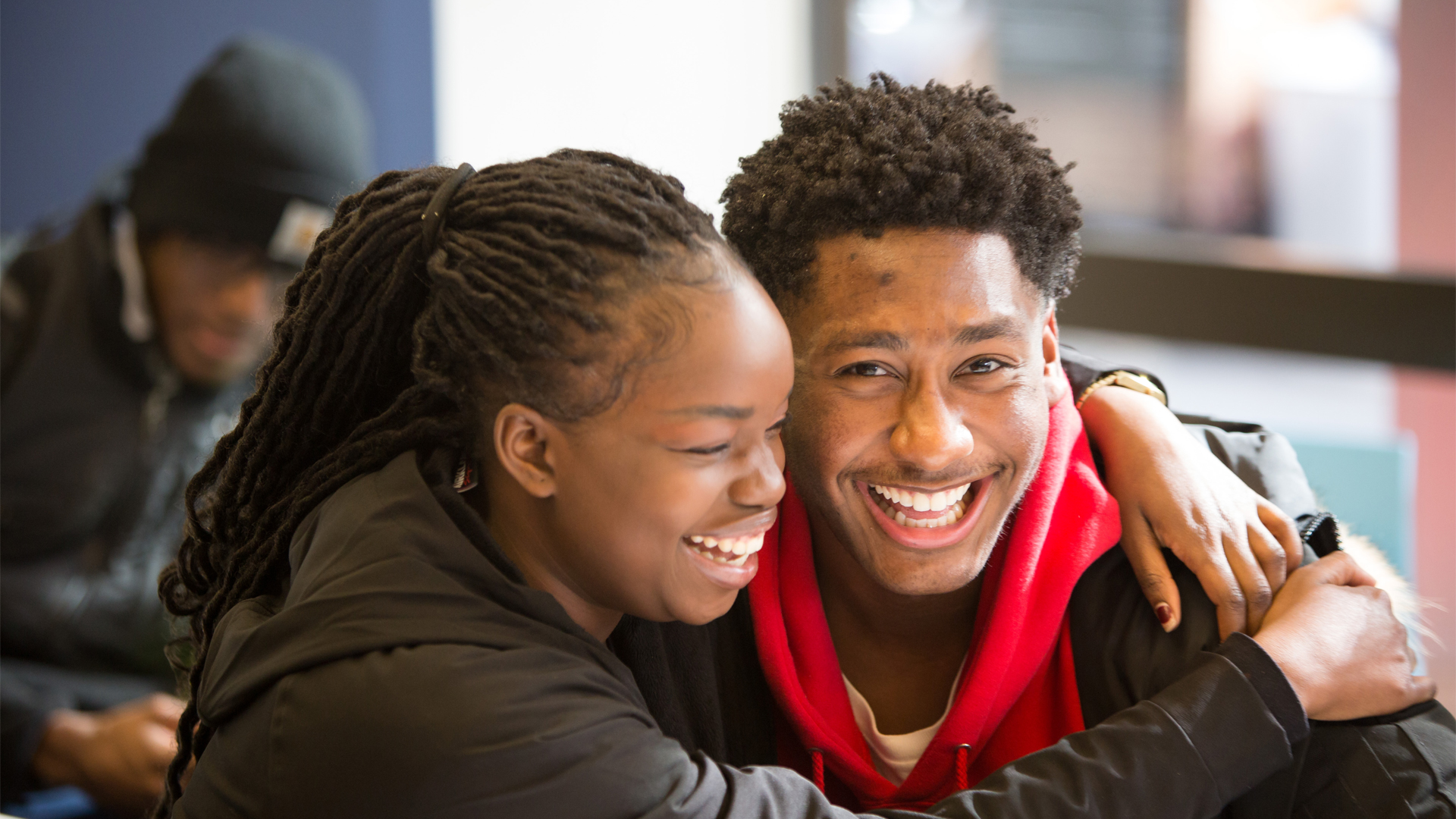 Two smiling students hug at New York Tech.