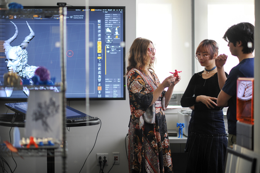 A faculty member displays a 3-D project to students.