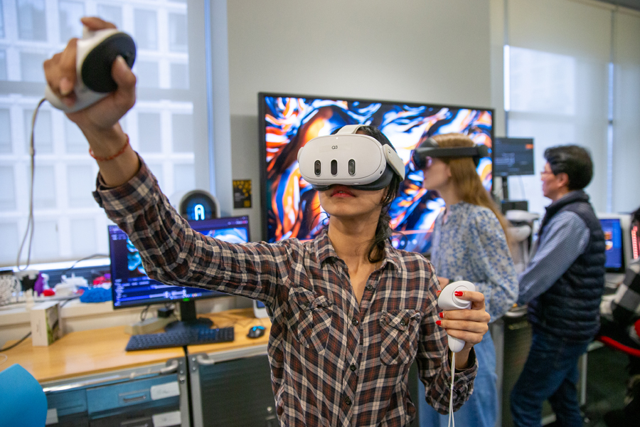 A student with VR googles experiments with technology in the HIVE.