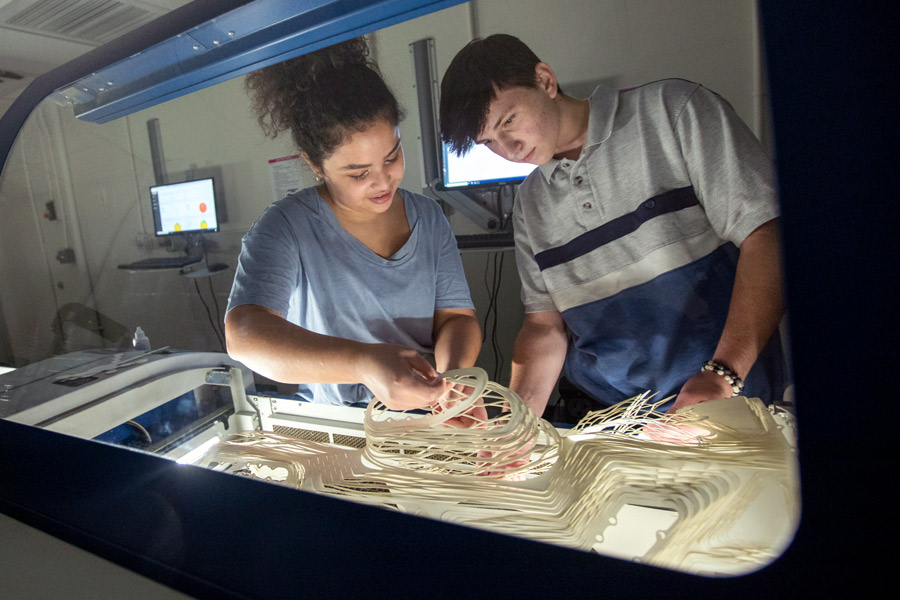 In one of New York Tech's design spaces, two School of Architecture and Design students develop a 3-D model out of a fine material.