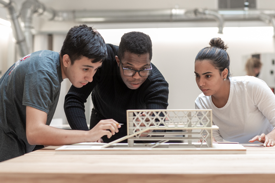 Three students working on a project created in the fabrication lab. 