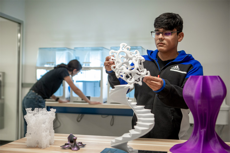 A student working on a 3D printed model in a fabrication lab.