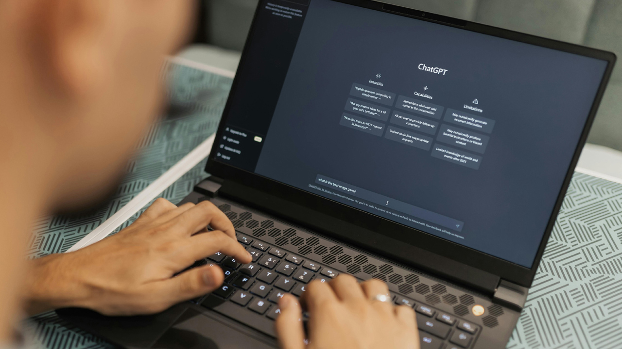 Student using a laptop on a table with ChatGPT on screen