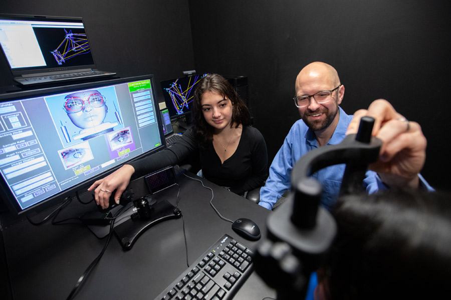 In one of New York Tech's psychology labs, a student and a professor use software to study eye movement in relation to human psychology.