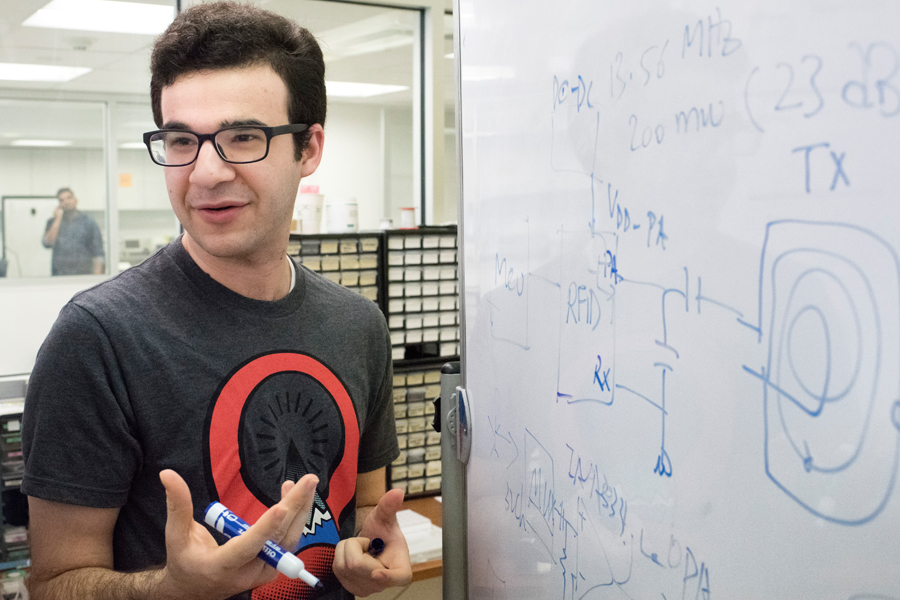 A presenter drawing a circuit diagram on a whiteboard.