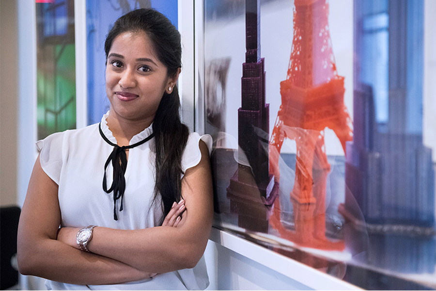 A person posing in front of framed artwork. 