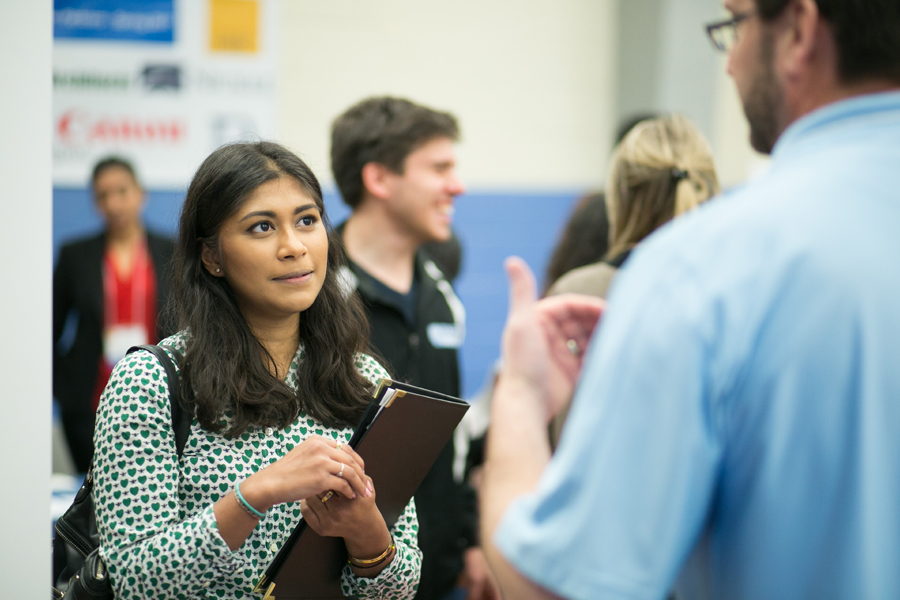 A student at a job fair meeting with potential employers. 