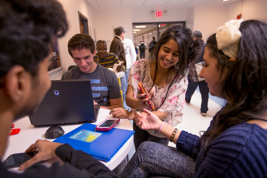 Student studying at a round table in a hallway. 