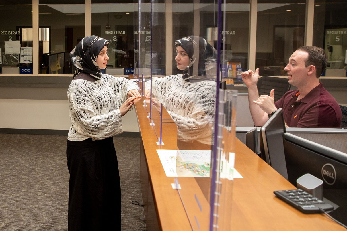 An administrator from New York Tech's Office of Financial Aid discusses a form with a student.