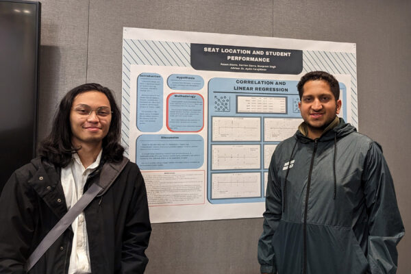 Two students in front of a project board.