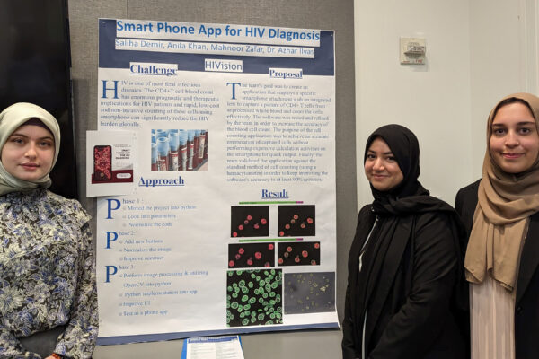 Three students standing in front of their project board.