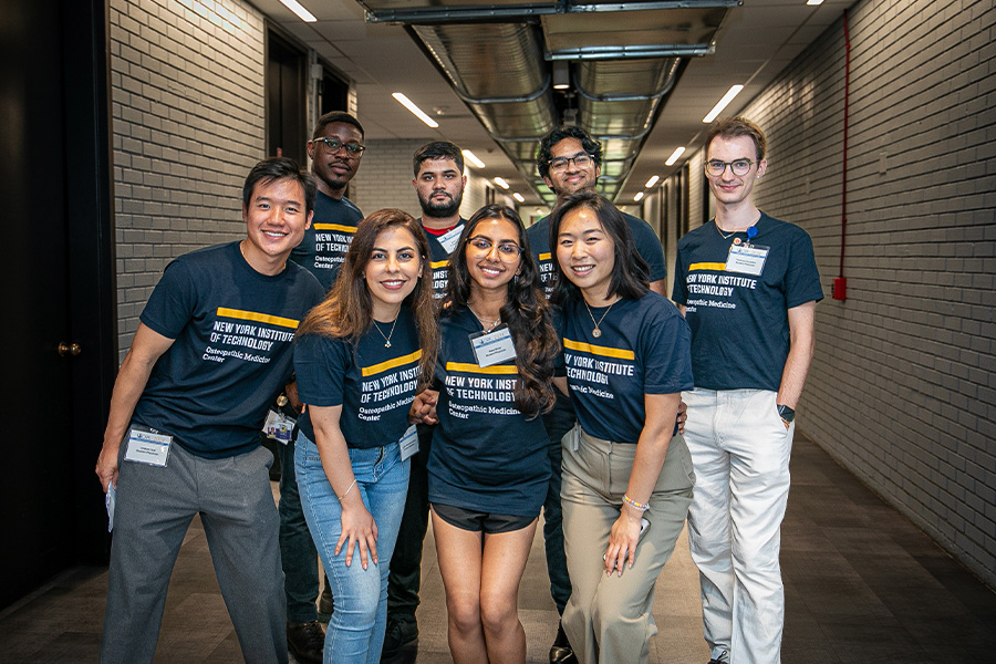 Group shot of NYITCOM students in blue New York Tech shirts.