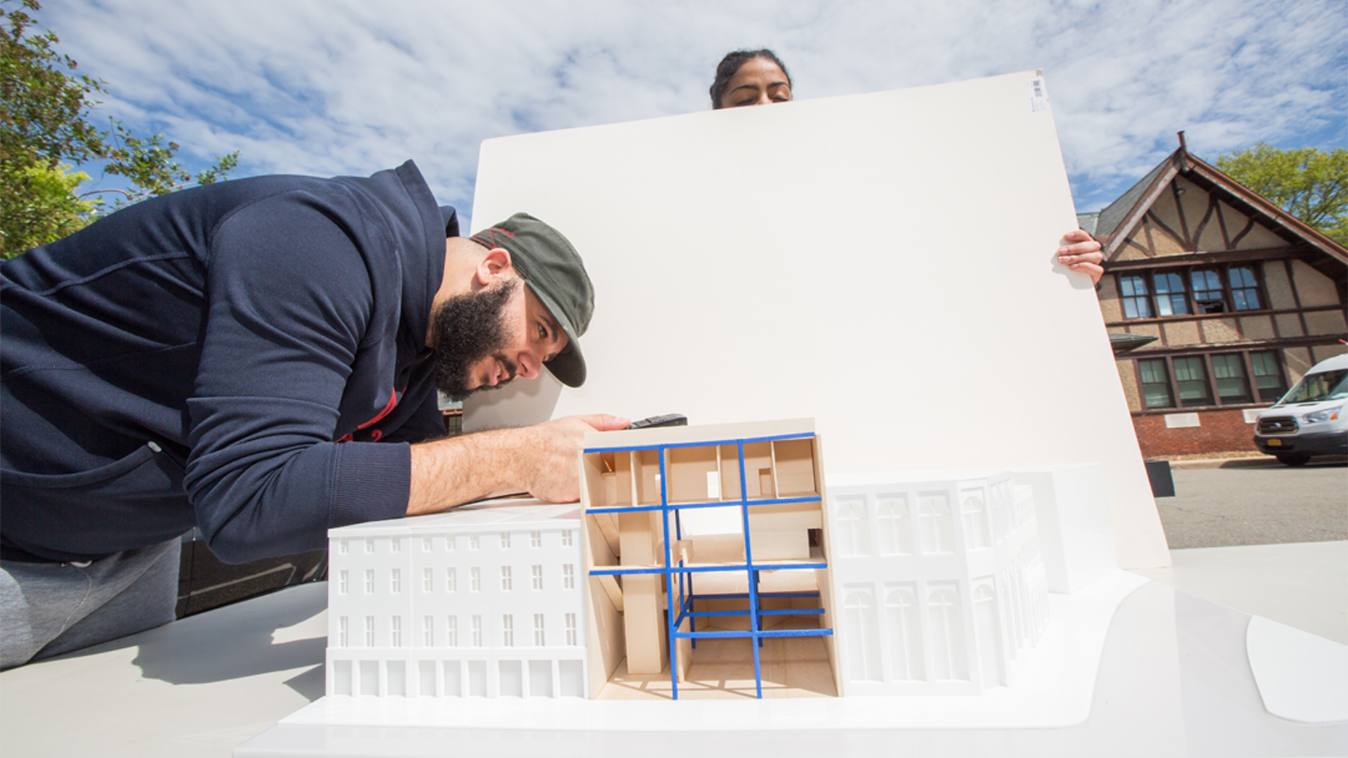 Two students work on an interior design project outside.