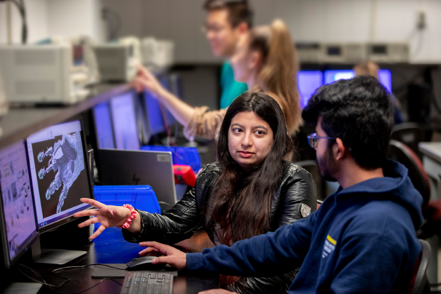 Two students having a discussion in a computer lab.