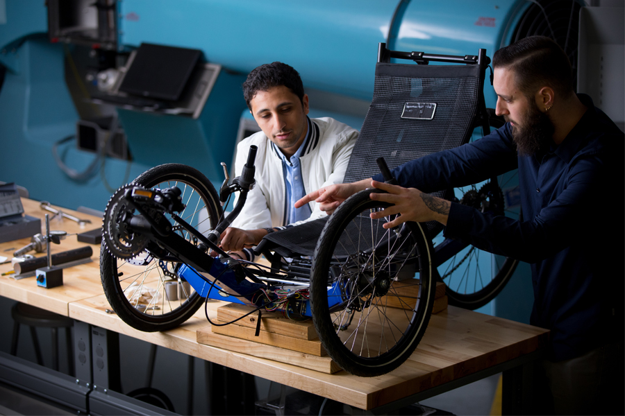 Two students working a mechanical engineering project.