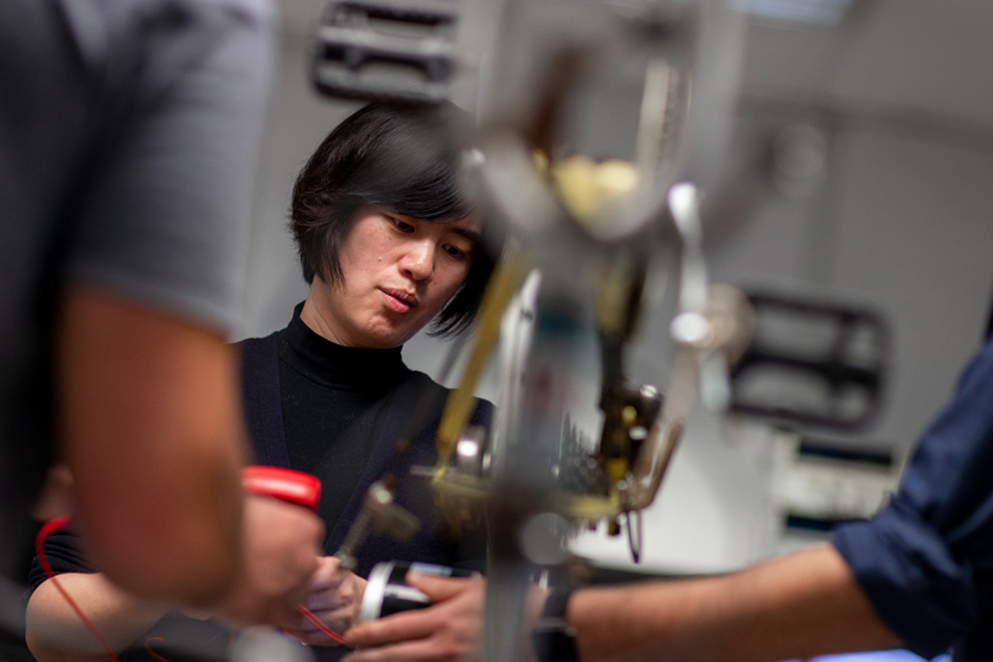 A faculty member in the College of Engineering and Computing Sciences observes a student project. 