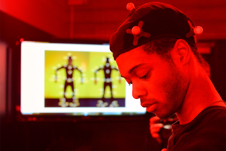 A student had motion capture technology attached to his body to capture his motion onto a screen.