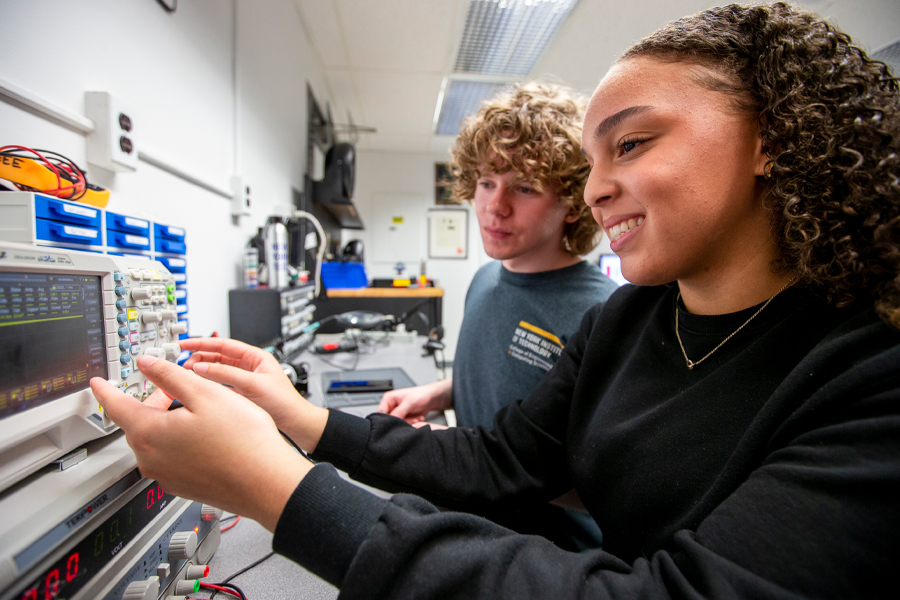 Two electrical and computer engineering students at New York Tech, one male and one female, get hands-on experience with industry-specific testing equipment.