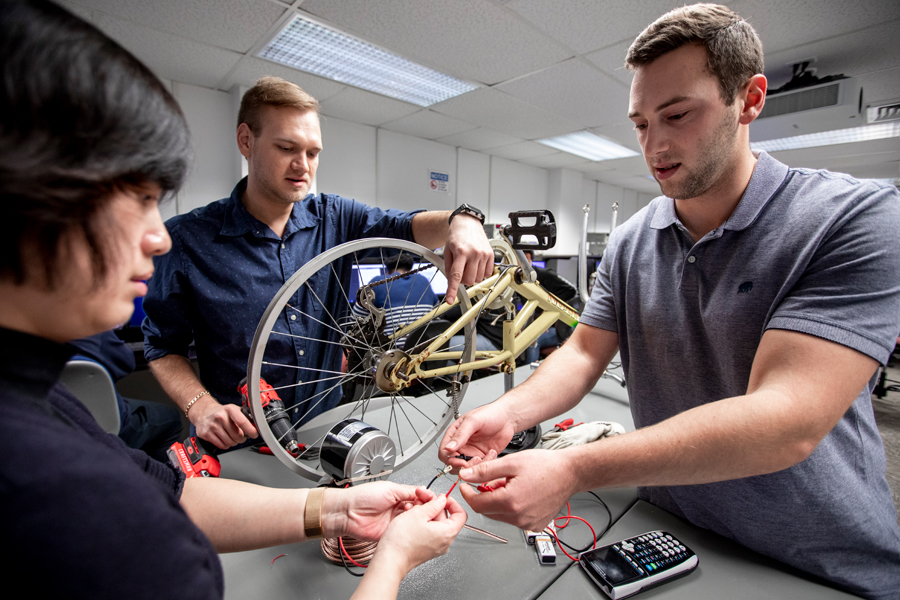 Three College of Engineering and Computing Sciences students at New York Tech structure an experiment using wires and bicycle parts.