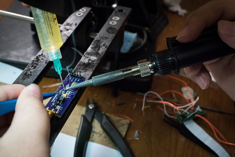 A close-up of a soldering iron being used on a circuit board. 