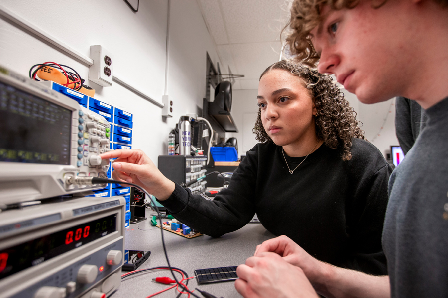 Two students in a lab working on a electrical engineering project. 