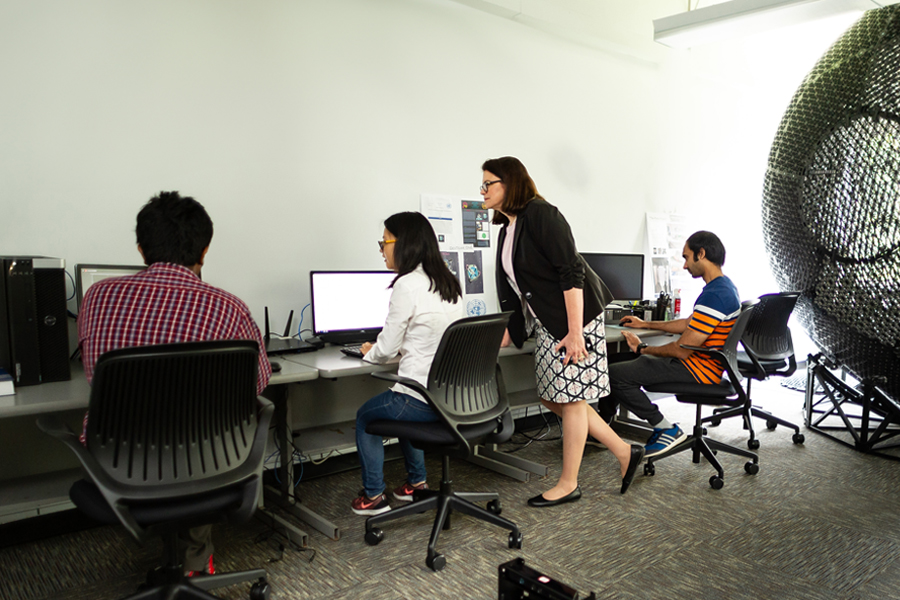 Three students work with a faculty member in the College of Engineering and Computing Sciences in the Entrepreneurship and Technology Innovation Center (ETIC).