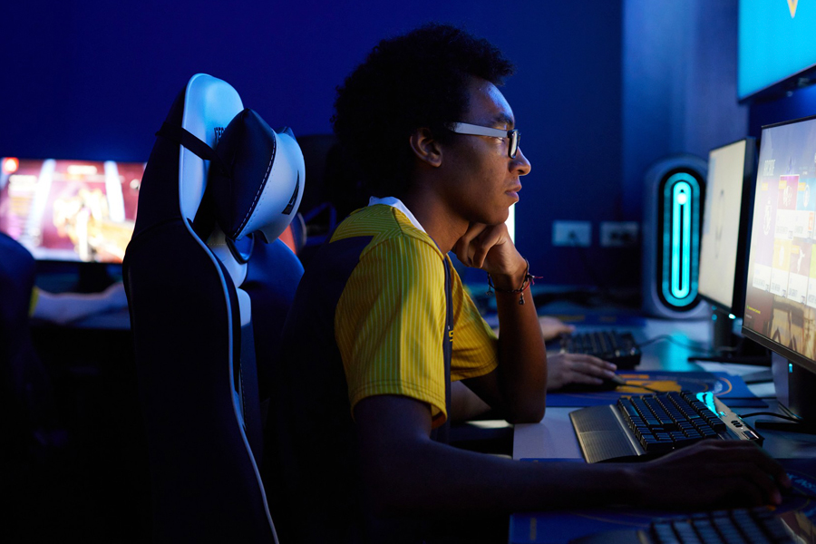 A student in uniform playing our esports lab.