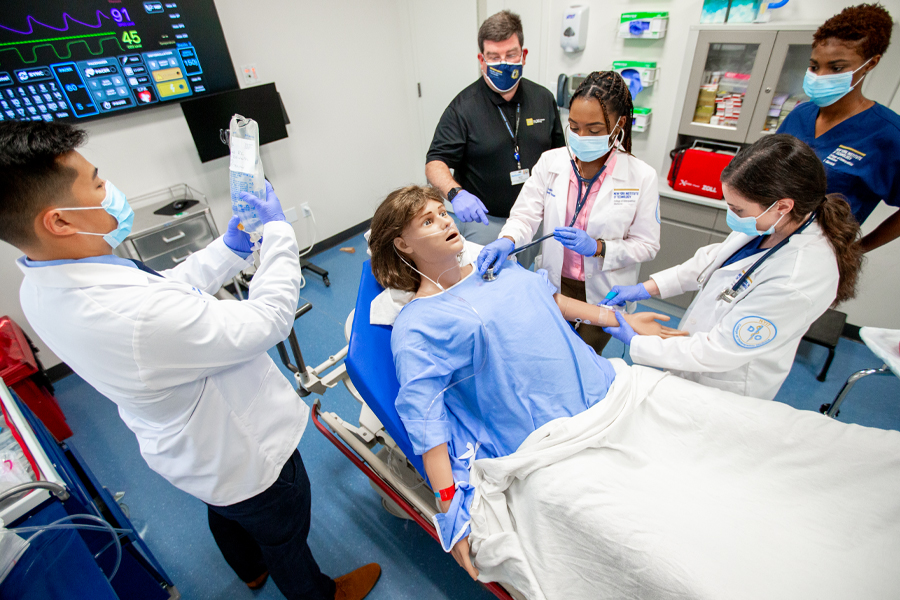 Five students wearing protective gear working in a simulation lab.