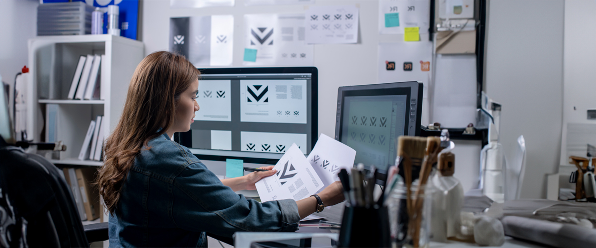 A student works on a graphic design project with black and white symbols.