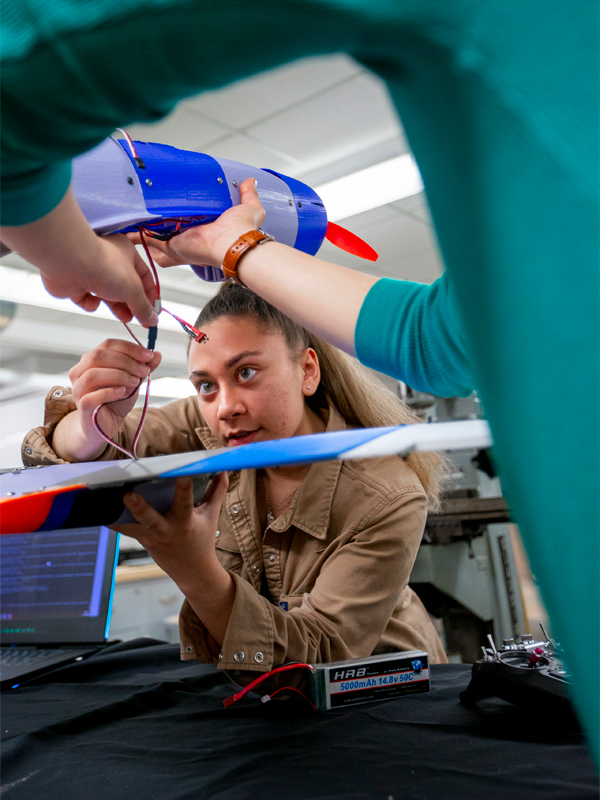 A student is working on a model airplane as part of a mechanical engineering assignment.