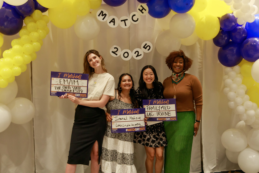 Students holding signs with their matches and balloons above them