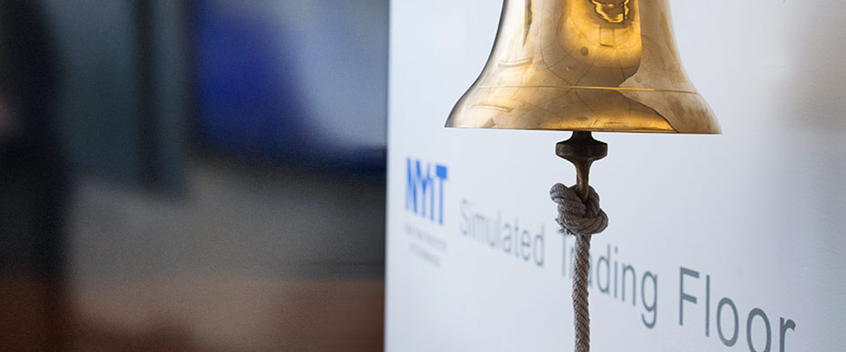 Stock bell in front of sign saying Simulated Trading Floor.