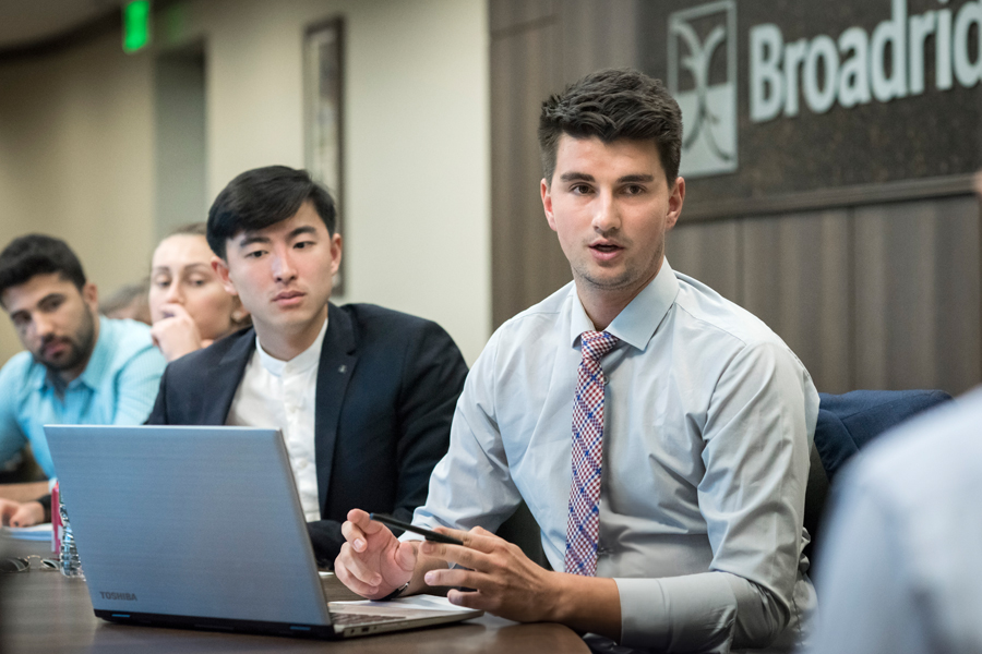 A group of students conduct a meeting at a financial organization.