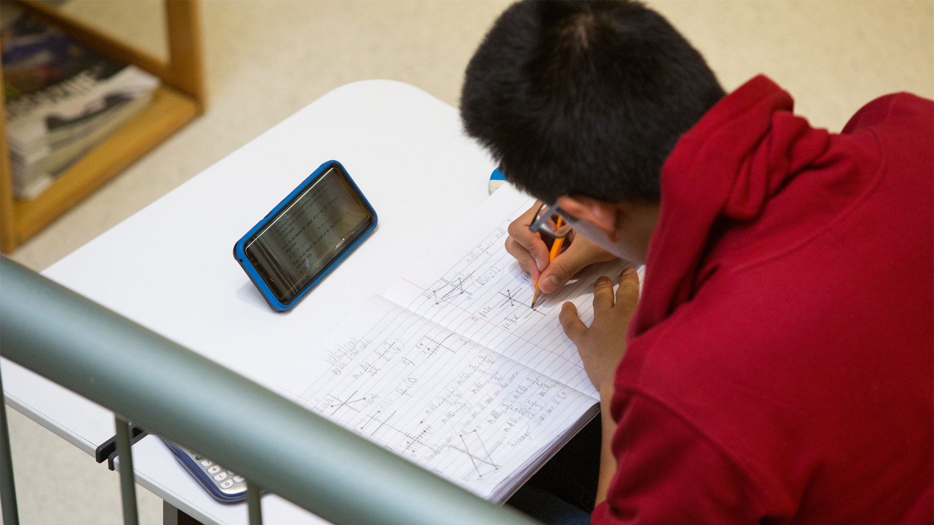 A student works on math equations in a study area at New York Tech.