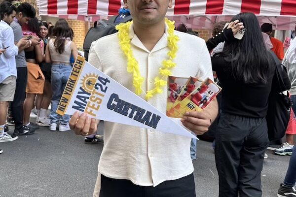 Student holding New York Tech Mayfest Swag